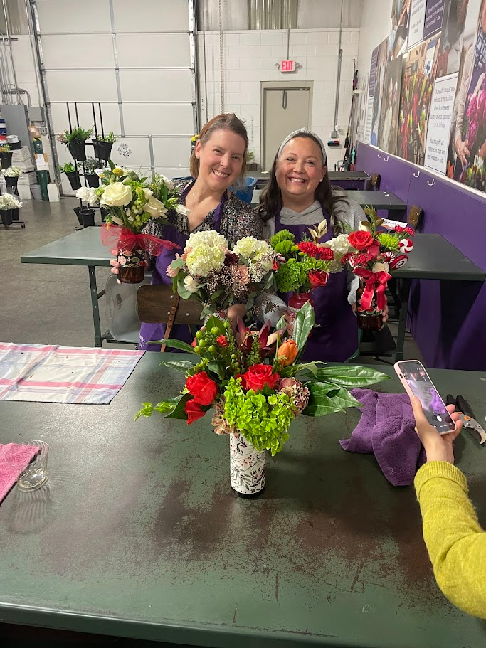 Sister survivors assembling flower bouquets for patients