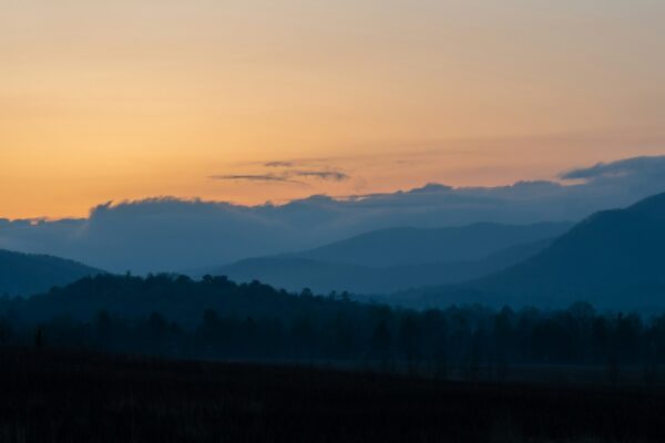 Sunrise over the Great Smoky Mountains, silhouetted ridges against an orange sky